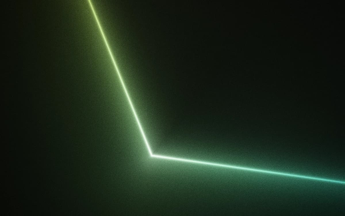 A razor seam of chartreuse-to-cyan light folding to a bright point low on a grainy black field